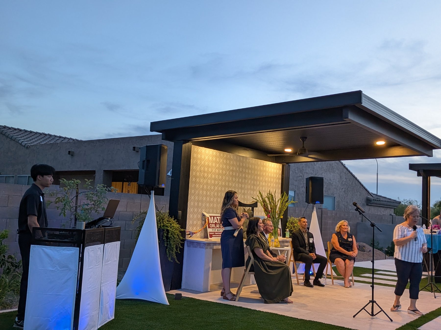 DJ setup with speakers and uplighting at an outdoor event